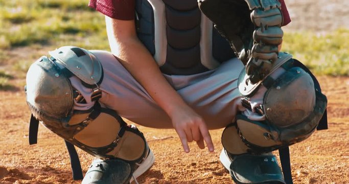 CU TILT UP Catcher kid boy baseball player calls for pitches using hand signals. 4K UHD 60 FPS SLO MO RAW