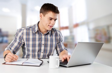 Happy young man works on his laptop