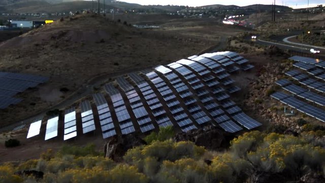 Sunset over solar panels conforming to the hill