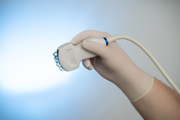 Ultrasound probe in hand with gel backlit