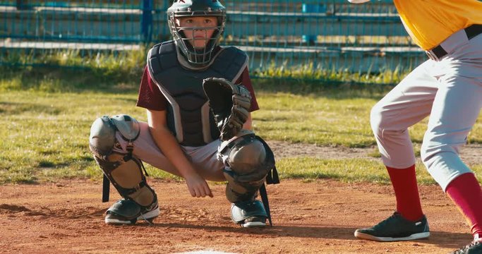 Baseball players batter and catcher kid boys baseball players prepare to receive a ball from pitcher. 4K UHD 60 FPS SLO MO RAW