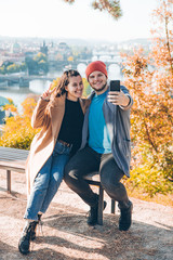 Obraz premium couple taking selfie on phone. autumn prague on background