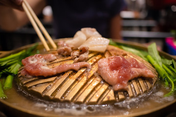 Thai barbecue buffet. Sliced pork on hot pan.