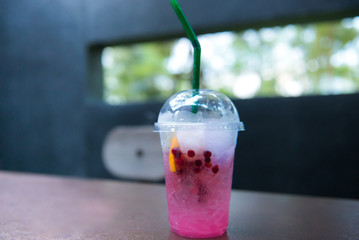 Infused pomegranate water with ice on the table in outdoors cafe.