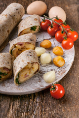 Omelet roll with ham, cheese and herbs. Tasty breakfast. Close Up