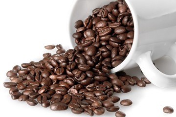 Mug full of, and surrounded by, coffee beans
