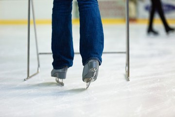 Close-up of Legs in Skates on Skating Rink