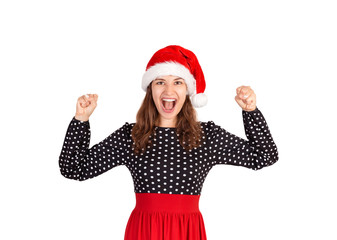 portrait of shouting fearfully and squeezing raised fistsg girl, being very excited. emotional girl in santa claus christmas hat isolated on white background. holiday concept