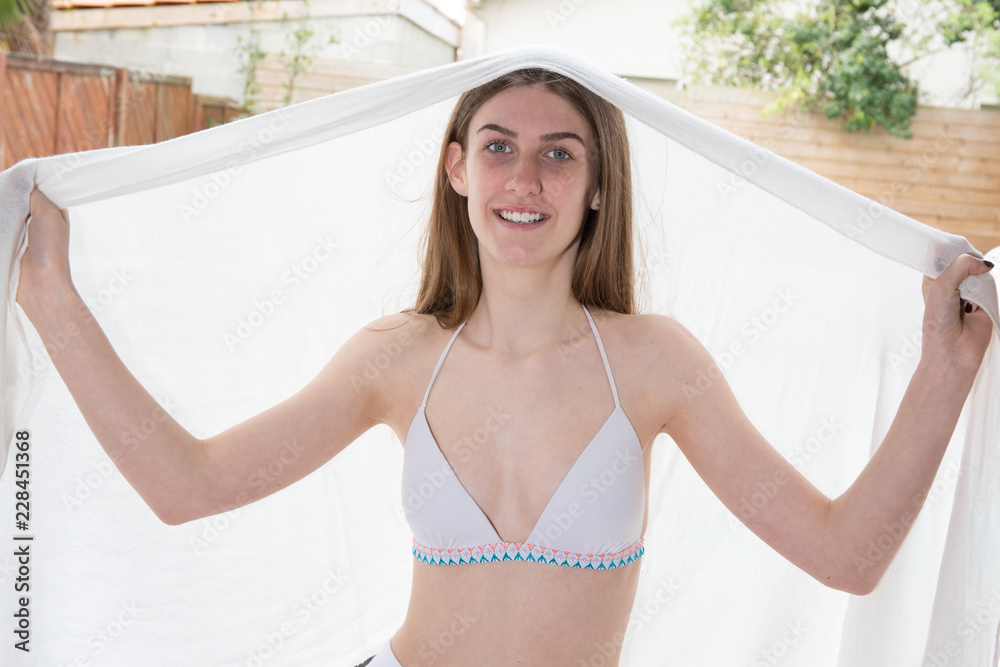 Wall mural Cheerful young woman in white sarong at home play and fun