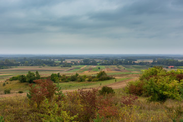 Autumn and last work in the fields, cloudy dark sky, end of the agricultural season, a small village in the south of Poland