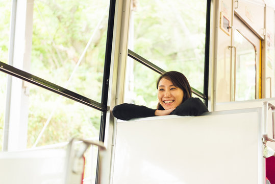 ケーブルカーの中でおどける女性