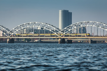 Obraz premium Railway bridge in Riga over the Daugava River in the fall in October on a sunny day