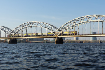 Obraz premium Railway bridge in Riga over the Daugava River in the fall in October on a sunny day