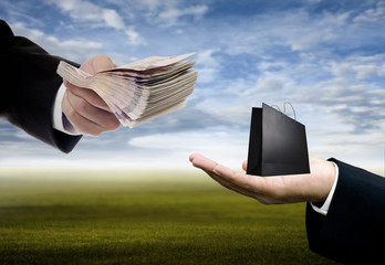 Shopping concept, Businessman offer cash for shopping bag in hand