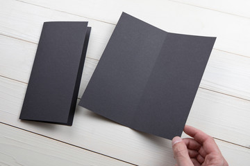 Mens hands holding empty black booklet