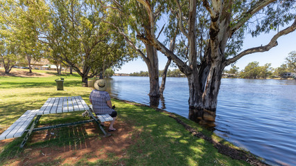 Mature women sitting at park bench enjoying the view of the Murray River at Morgan in South...
