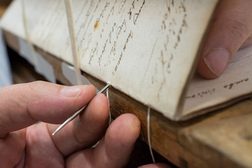 Restoration laboratory. Stitching and binding of an old book, conservation
