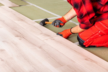 Handyman installing wooden floor
