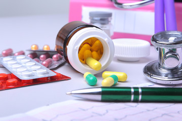 Close-up stethoscope lying on RX prescription with assorted pills. Healthy life or insurance...