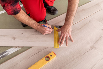 Handyman installing new laminated wooden floor
