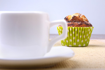 Homemade Chocolate chips muffins with coffee on wooden background