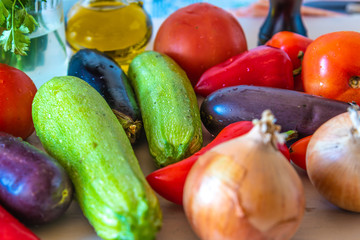 Fresh raw rustic vegetables for vegetable stew - eggplants, zucchini, tomatoes, onions, peppers, top view