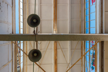 The two lamps hanging under the roof of the industrial building