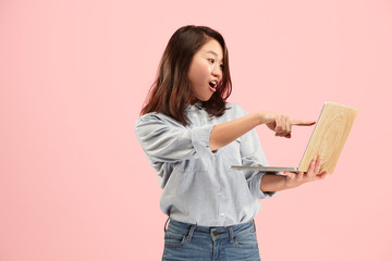 Naklejka premium Businesswoman with laptop. Love to computer concept. Attractive female half-length front portrait, trendy pink studio backgroud. Young emotional pretty woman. Human emotions, facial expression