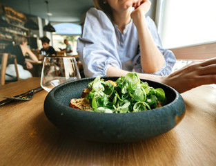 Pensive french woman talking in restaurant delicious green gourmand organic salad