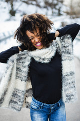 Young expressive black woman having fun in winter outdoor.