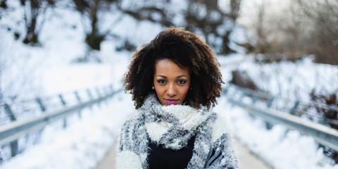 Stylish afro hair woman winter portrait. Female wearing warm wool scarf.