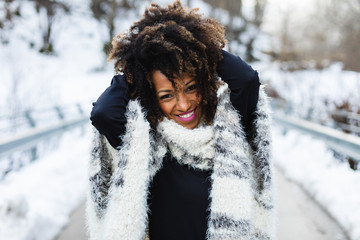Young expressive black woman having fun in winter outdoor.