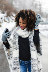 Cheerful woman taking selfie photo with smartphone in winter.