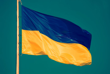 Fototapeta na wymiar Ukrainian flag against a blue sky. Yellow and blue colors. National symbol of Ukraine. Modern toned photo.