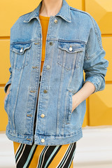 Stylish feminine look from a jean jacket, yellow top and skirt. Street style.