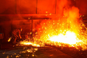 iron works blast furnace taphole spewing molten iron