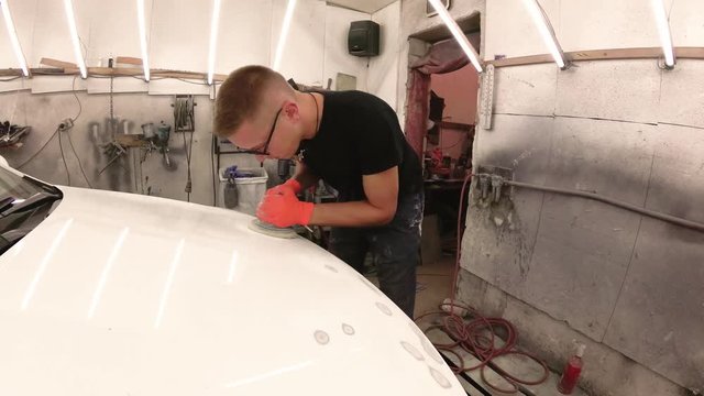 young man repairs cars in the garage.