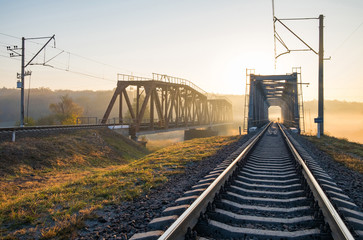 Fototapeta na wymiar Railway bridge over the Irpin River in the autumn foggy morning.