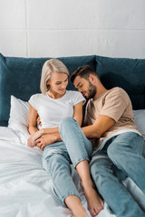 attractive young couple embracing together in bedroom