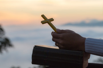 Women hand  pray to God with the Bible and the cross of the morning. Woman Pray for god blessing to...