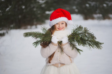 little happy beautiful girl in winter forest