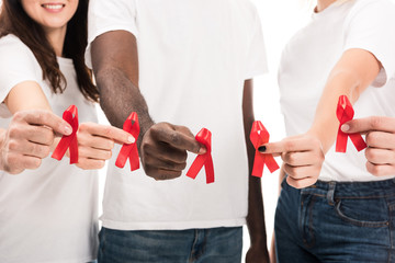 cropped shot of group of people in blank white t-shirts holding aids awareness red ribbons isolated on white