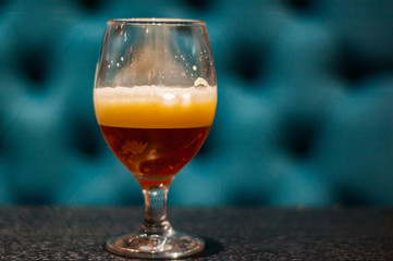 Close up on a glass of amber Pale Ale beer on wooden table in bar with copy space.