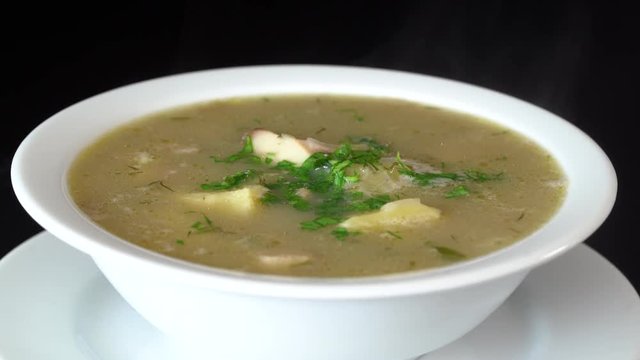 Vegetable soup with mushrooms and potatoes. Healthy food, mushrooms soup in white plate, close up, rotates