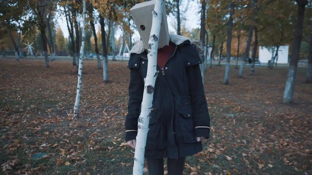 Girl with a pack on your head hides behind a tree