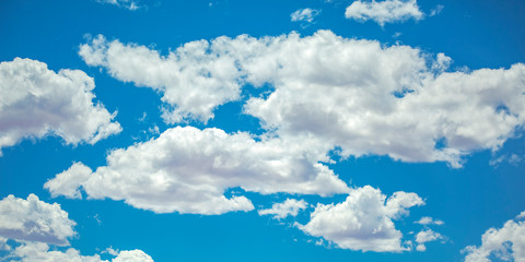 Obraz na płótnie Canvas Vibrant blue sky with illuminated puffy clouds