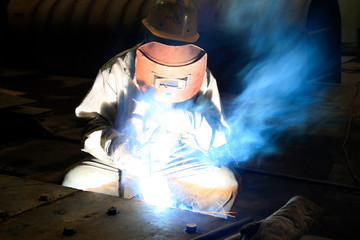 Worker welding parts in the production workshop