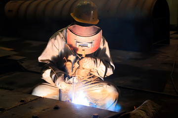 Worker welding parts in the production workshop