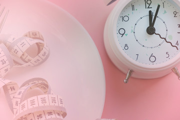 Time to lose weight , eating control or time to diet concept , alarm clock with healthy tool concept decoration on pink background
