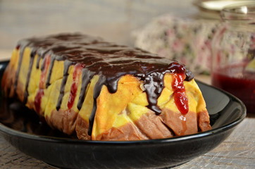 Vanilla chocolate cheesecake with chocolate glaze on a black dish